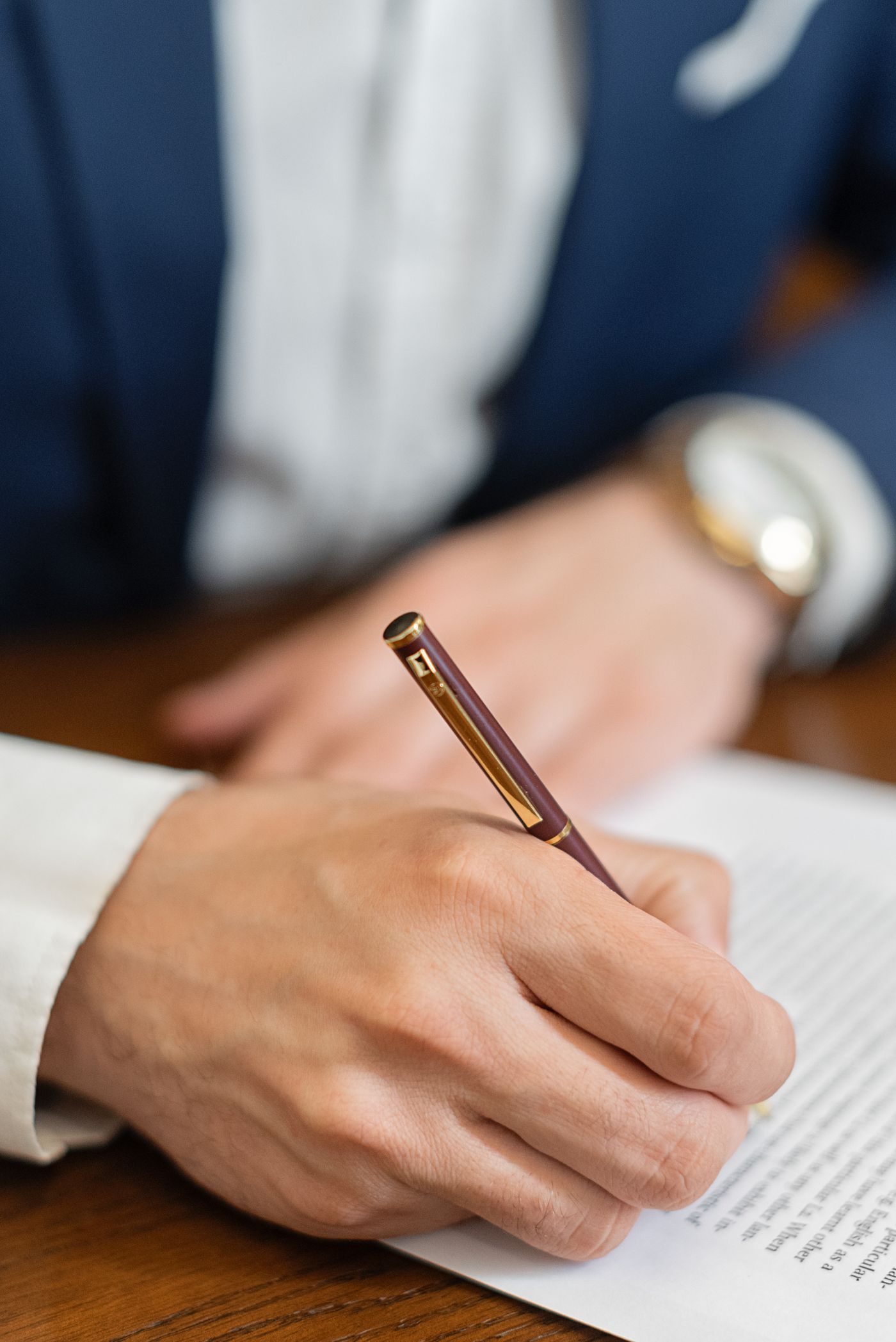 A close-up of a hand signing a legal document with a pen
