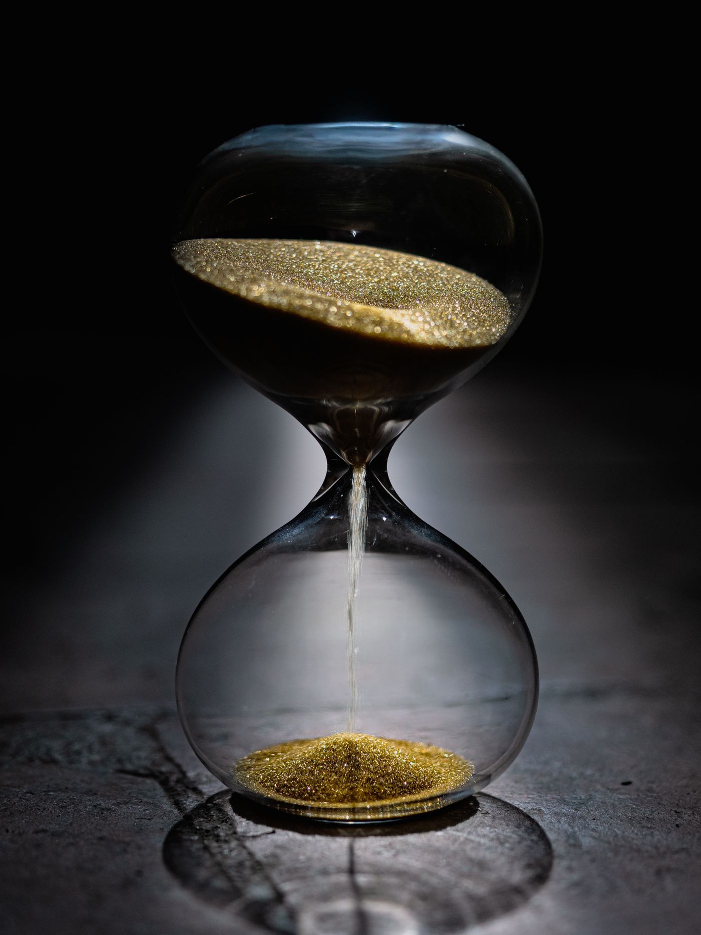 An hourglass with sand flowing away on a dark surface — time running against a legal claim