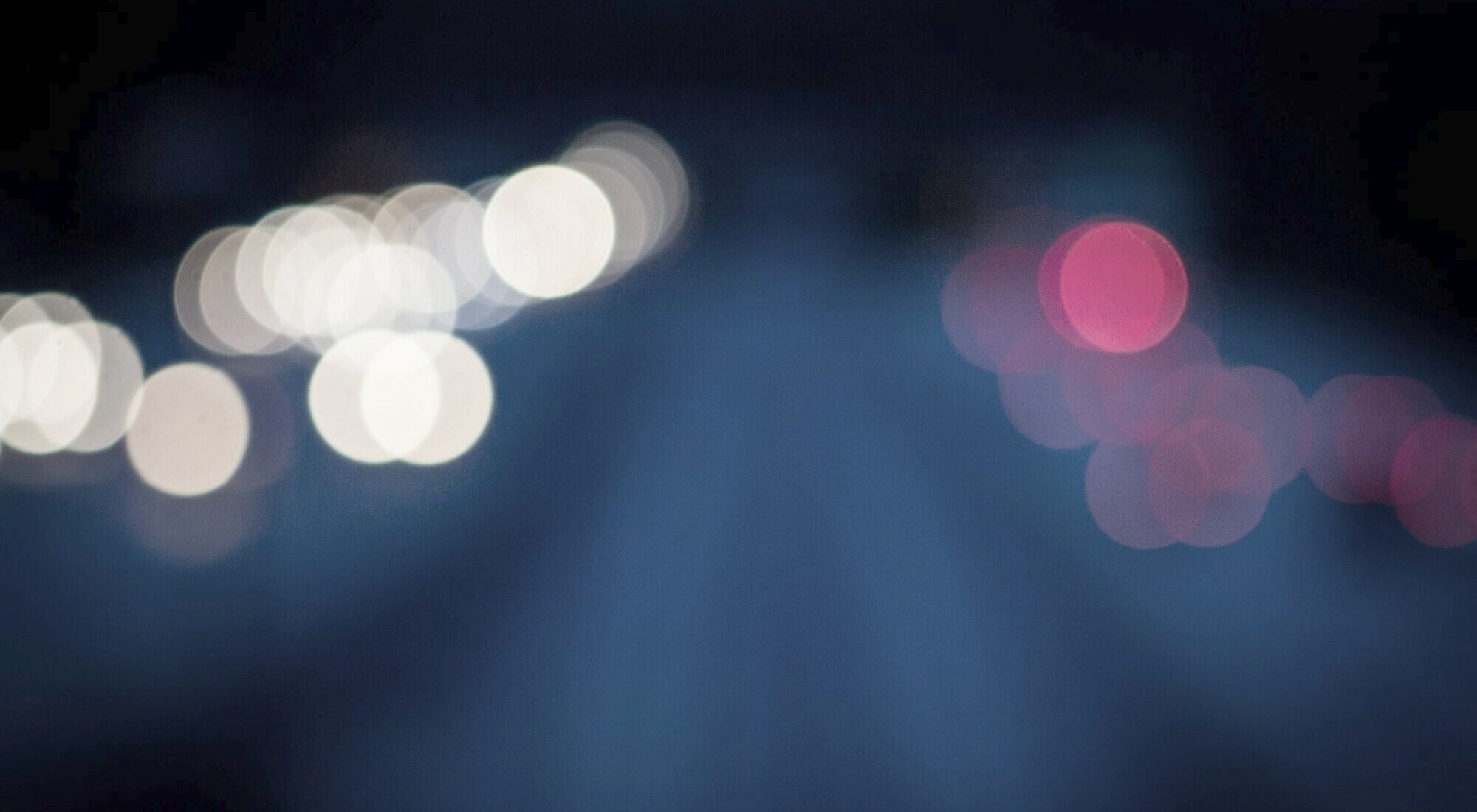 Blurred red and blue lights against a dark night sky